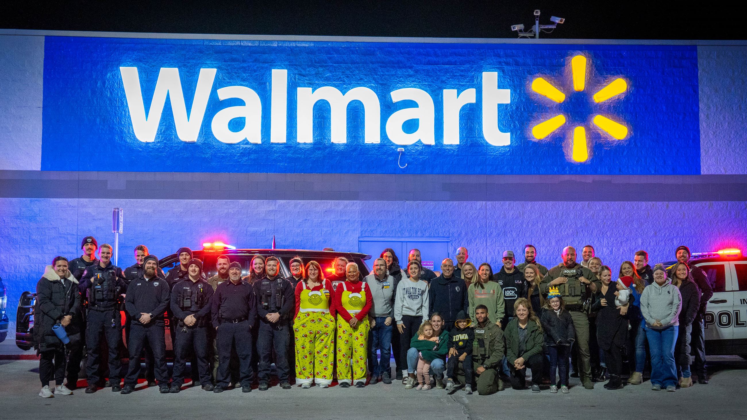 Indianola Police Department officers, families and Walmart employees stand outside store.