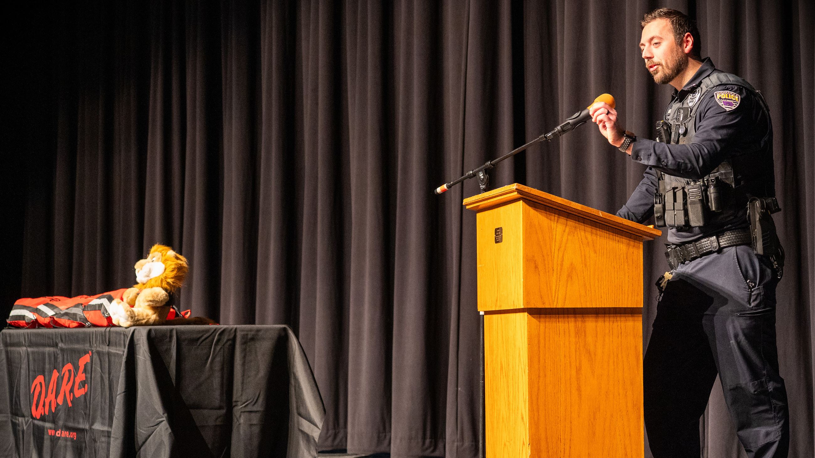 School Resource Officer Ross Marshall speaks at a podium during the DARE program graduation.