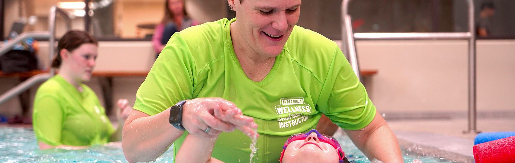 An Indianola Wellness Campus employee leads a swim lesson for a youth participant.