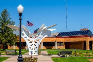 A flag waves in the wind outside Indianola City Hall on a warm sunny day.