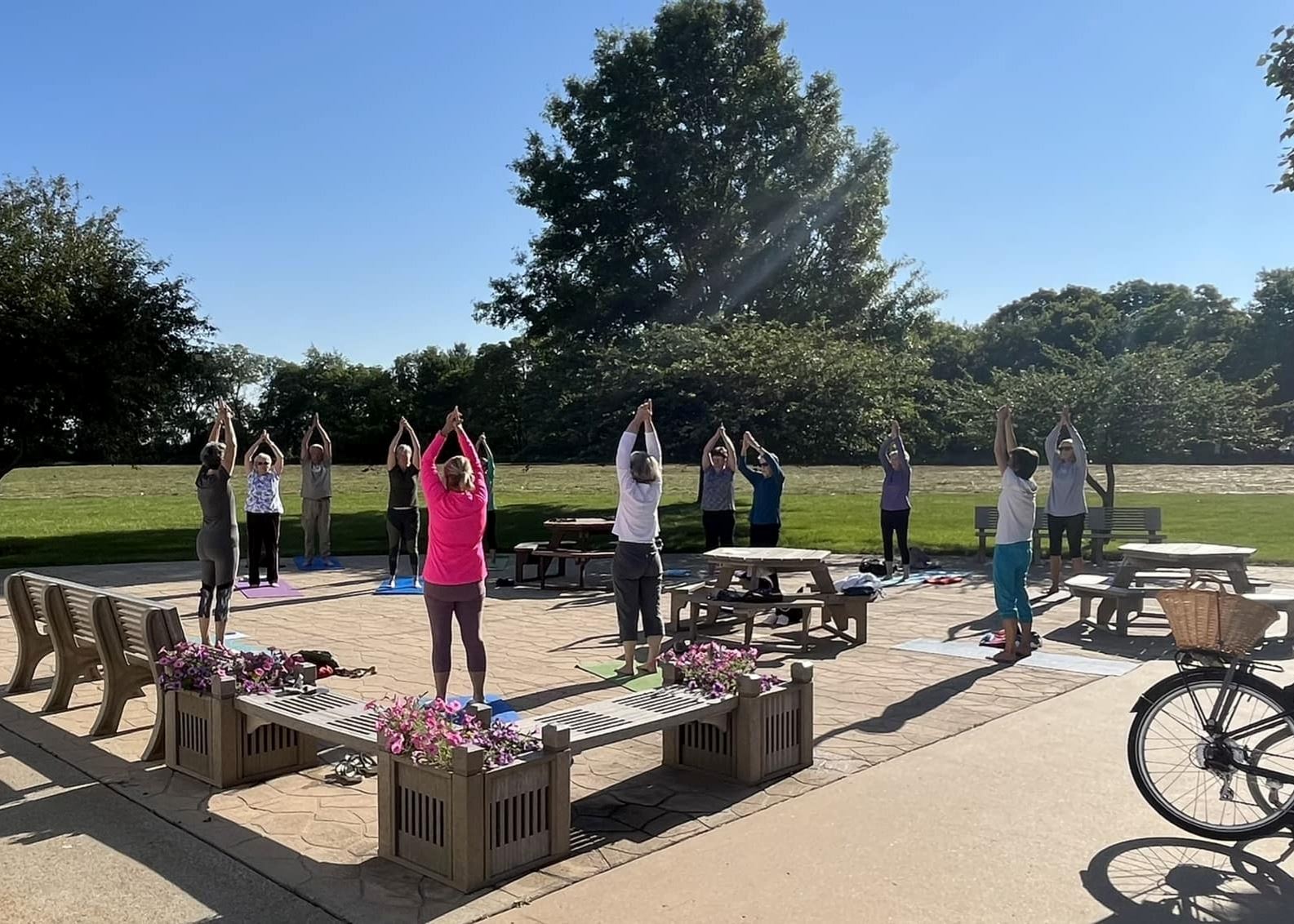 Men and women practice yoga on the patio at the Indianola Activity Center