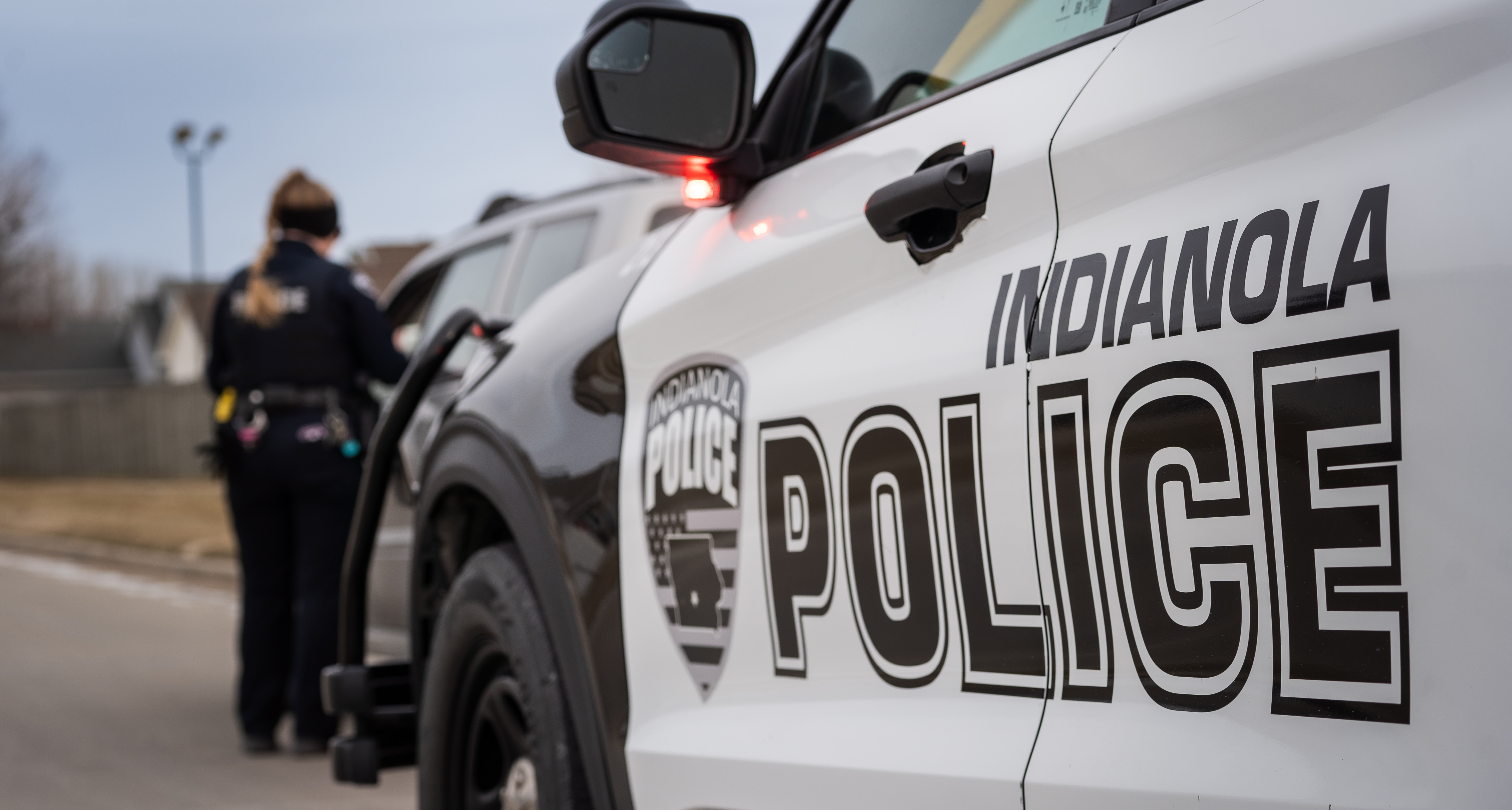 A police officer pulls over a vehicle on a street during the day time.
